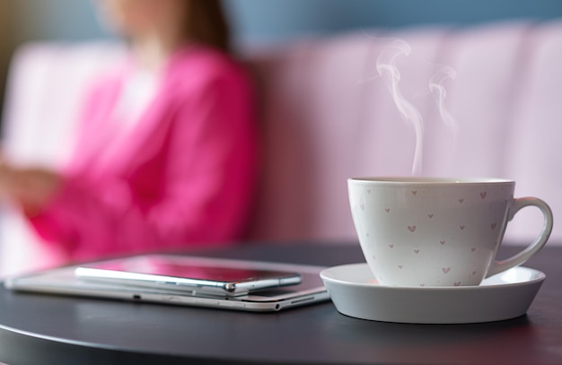 Odświeżająca filiżanka gorącej kawy w kawiarni na tle niezależnej dziewczyny