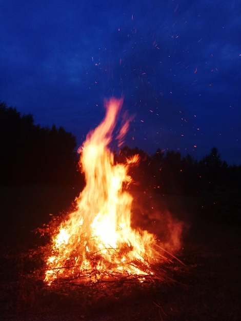 Zdjęcie ogień na polu przeciwko niebu w nocy