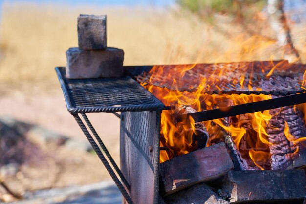 Zdjęcie ogień w zardzewiałym vintage grill na plaży morza