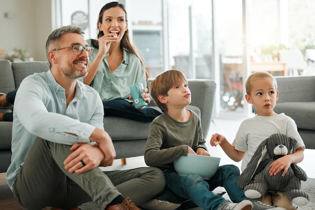 Oglądaliśmy nasz ulubiony film Ujęcie młodej rodziny oglądającej razem telewizję w domu