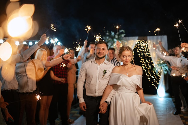 Ognie na weselu nowożeńców w rękach radosnych gości