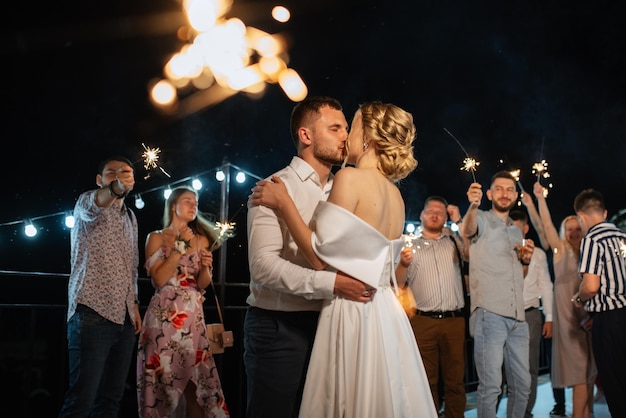 Ognie na weselu nowożeńców w rękach radosnych gości