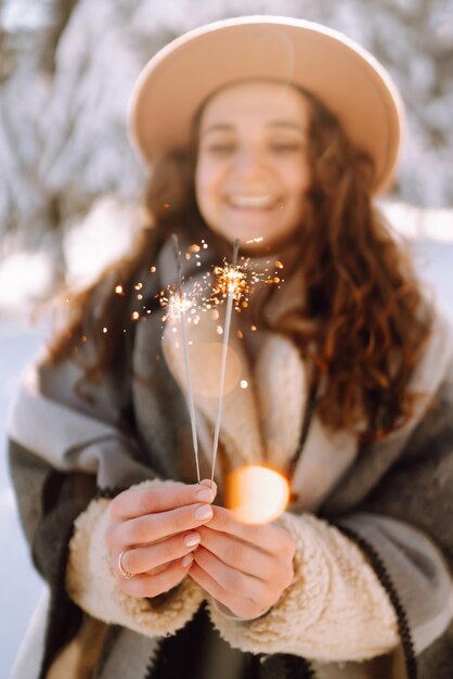 Zdjęcie ognie w rękach młodej kobiety. smilling kobieta korzystających z zimowych chwil.