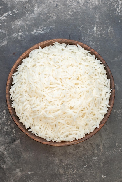 Ogólny widok idealnego długiego ryżu w brązowej misce na szarym tle z wolną przestrzenią