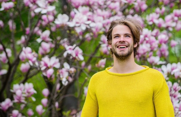 Ogród Botaniczny. Świeżość i przebudzenie. Przetargowe kwiaty. Hipster lubi kwiat. Koncepcja wiosny. Facet relaksuje się w parku kwiatów. Botanika i przyroda. Mężczyzna kwiaty tło niewyraźne. Piękno wiosny.