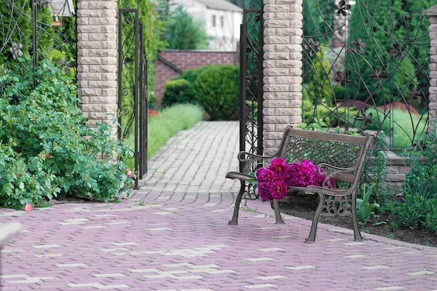 Ogród kwiatowy i ławka w stylu vintage Bukiet piwonii na ławce w pobliżu prywatnego domu