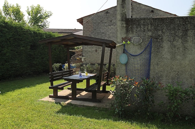 Ogród oliwny z krzesłami, leżakami, huśtawkami, stołami do ping ponga i stołem jadalnym