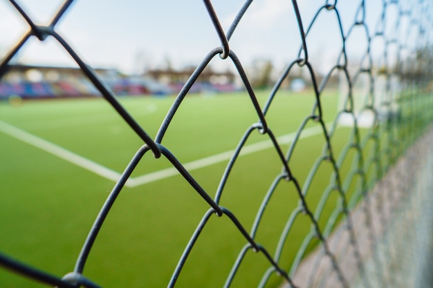 Ogrodzenie z siatki stalowej na stadionie sportowym.