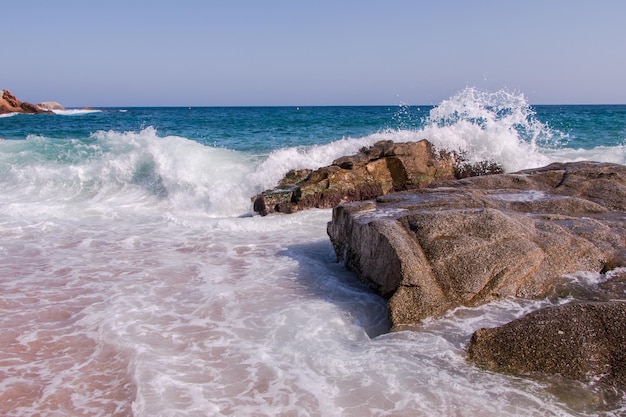 Ogromne fale uderzają o skały na plaży Finals w Llret de Mar w Katalonii