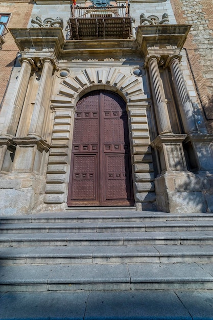 ogromne średniowieczne drewniane drzwi z wysokimi kamiennymi kolumnami, średniowieczny kościół w mieście Toledo, Hiszpania