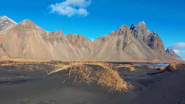 Ogromny łańcuch górski spotykający ocean, majestatyczne krajobrazy islandzkie z czarną piaskową plażą. Półwysep nordycki Stokksnes z górami vestrahorn i naturalną trasą malowniczą.