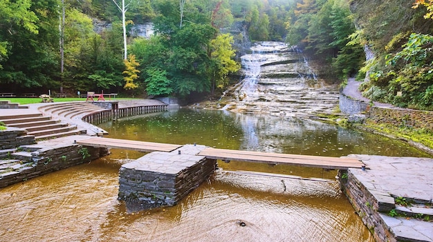 Ogromny wodospad schodzący do rzeki z mostem spacerowym i częścią wypoczynkową