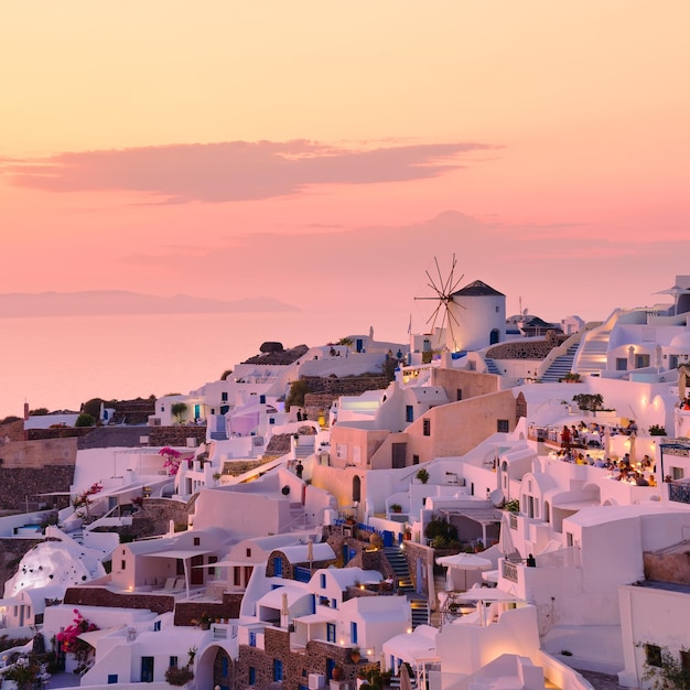 Oia village Santorini Grecja Widok tradycyjnych domów na Santorini Małe wąskie uliczki i dachy domów kościołów i hoteli Krajobraz podczas zachodu słońca Fotografia z podróży i wakacji