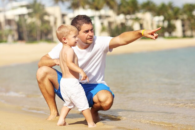 ojciec bawi się na plaży ze swoim synkiem