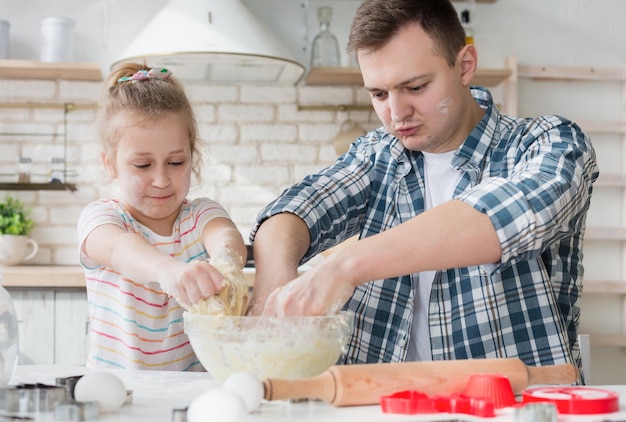 Ojciec gotuje ciasto z córką po raz pierwszy w kuchni, kopia przestrzeń