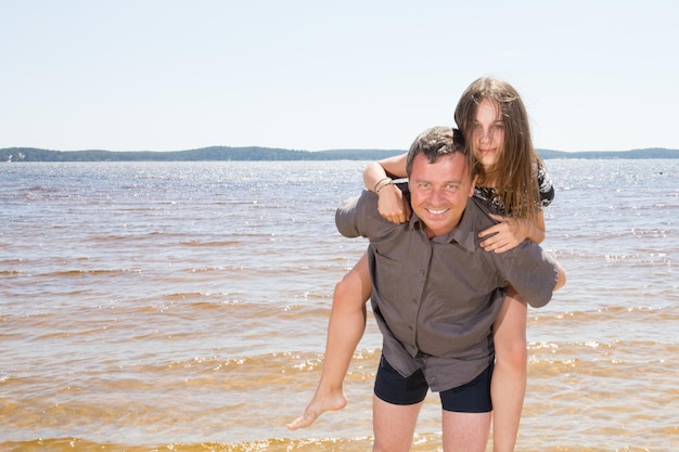 Ojciec i córka nastolatka bawią się na plaży w ciągu dnia Koncepcja przyjazna rodzinie