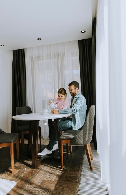 Ojciec i córka piją razem herbatę w salonie