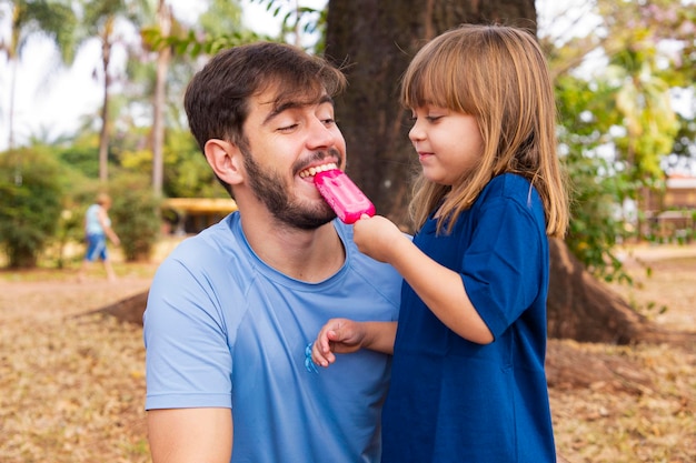 Ojciec I Córka W Parku Ssą Pyszne Popsicle