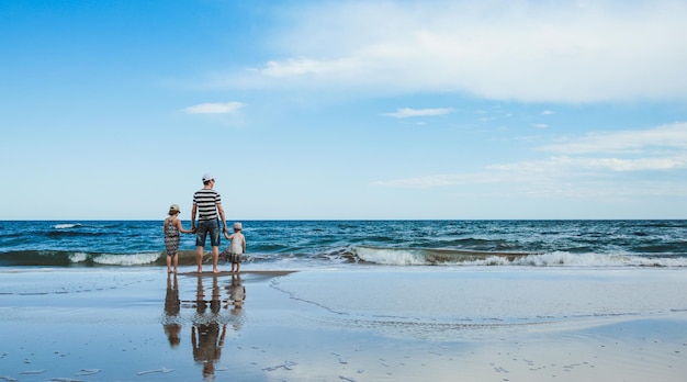 Ojciec i dwie córki stojące na plaży