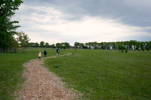 Ojciec i dwoje dzieci, syn i córka wędrują po lesie. Rodzinny spacer. Czas letni razem na kempingu. Szczęśliwego dnia ojca.