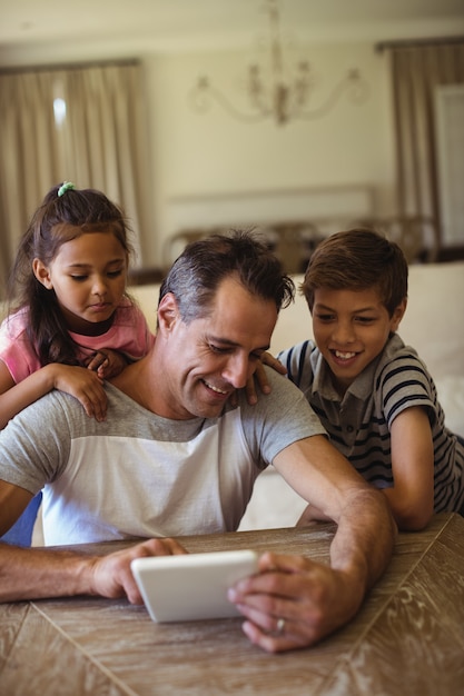 Ojciec i dzieci za pomocą cyfrowego tabletu w salonie