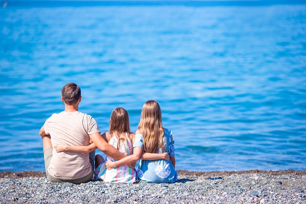 Ojciec i dziewczynki na plaży bawią się na wakacjach