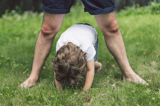 Ojciec i jego syn bawią się i przytulają na świeżym powietrzu