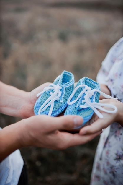 Ojciec i matka trzymają zbliżenie butów noworodka