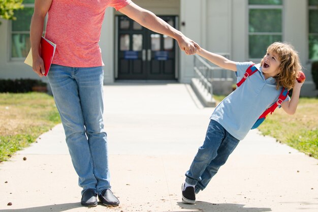 Ojciec i podekscytowany syn spacerują po szkolnym parku