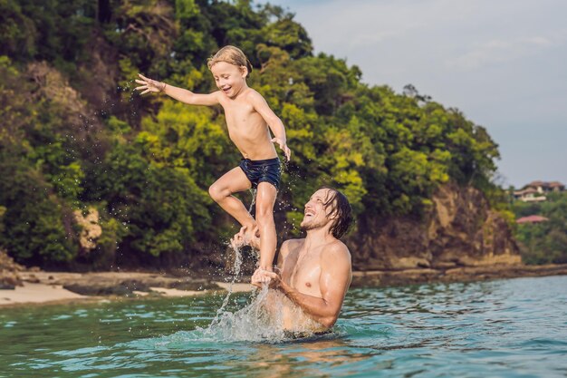 Ojciec i syn bawią się na plaży w ciągu dnia