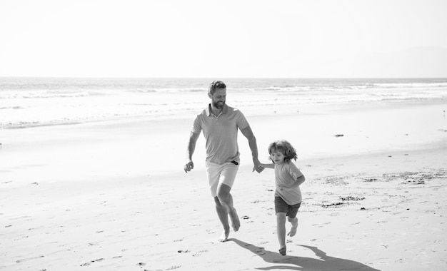 Ojciec i syn biegają na letniej plaży rodzinnej podróży weekend i wakacje