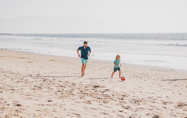 Ojciec i syn grają w piłkę nożną lub piłkę nożną na plaży tata i dziecko bawią się na świeżym powietrzu rodzinne podróże