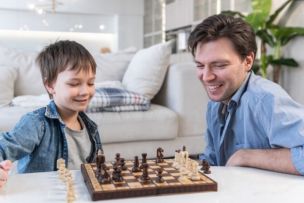 Ojciec i syn grają w szachy w domu
