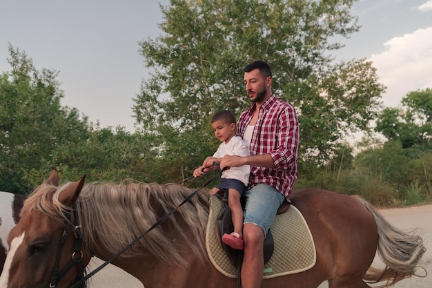 Ojciec i syn lubią razem jeździć konno nad morzem. Selektywne skupienie. Wysokiej jakości zdjęcie