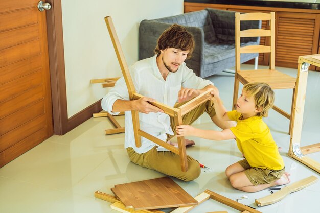 Ojciec i syn montują meble Chłopiec pomaga ojcu w domu Koncepcja Happy Family