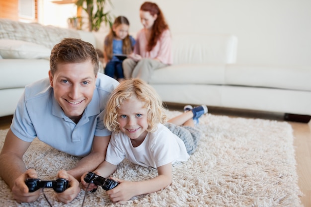 Ojciec i syn na podłodze, grając w gry wideo