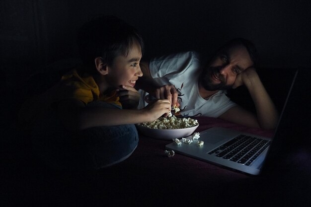 Zdjęcie ojciec i syn oglądają film na laptopie.