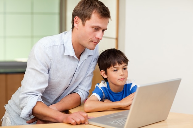 Ojciec i syn patrzeje laptop