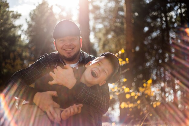 Ojciec i syn przytulają się w jesiennym parku płytka głębia ostrości Aktywne rodzinne wakacje