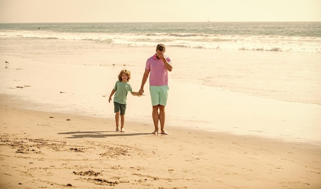 Ojciec i syn spacerują po letniej plaży rodzinnej podróży weekend i wakacje