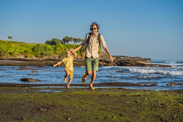 Ojciec i syn turyści na tle Tanah Lot - Świątynia na Oceanie. Bali, Indonezja. Podróżowanie z koncepcją dzieci