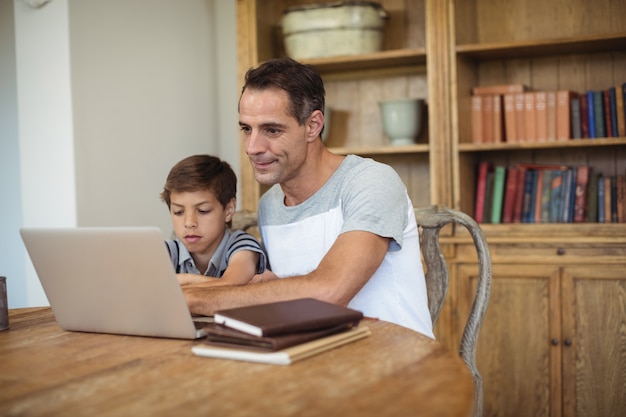 Ojciec i syn używa laptop w nauka pokoju