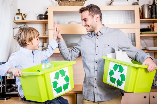 Zdjęcie ojciec i syn w domu z pojemnikami na odpady