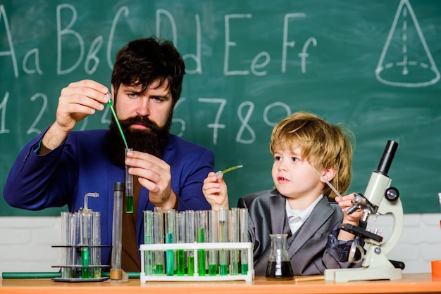 Ojciec i syn w szkole Powrót do szkoły nauka chemii w szkolnym laboratorium Badania naukowe i eksperymenty nauczyciel mężczyzna z małym chłopcem Biologia Laboratorium naukowe Występują utleniacze