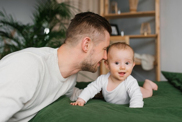 Ojciec i synek bawią się razem na łóżku w sypialni