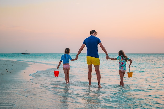 Ojciec i urocze małe dzieci na tropikalnej plaży, zabawy