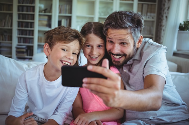 Ojciec Siedzi Na Kanapie Z Dziećmi I Klika Selfie W Salonie