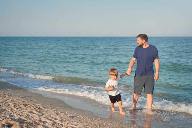 Ojciec syn spędza czas razem na morzu wakacje Młody tata dziecko mały chłopiec spaceru na plaży