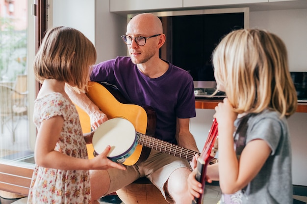 Zdjęcie ojciec uczy córki gry na gitarze i gry na instrumentach