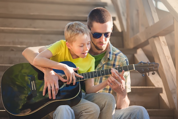 Zdjęcie ojciec uczy syna gry na gitarze